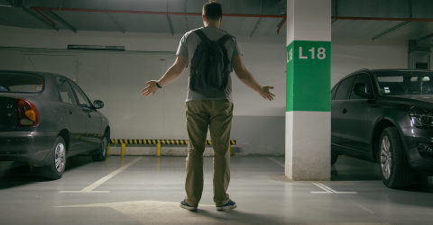 gestolen auto; man met armen op zij komt in de parkeergarage en zijn auto is weg